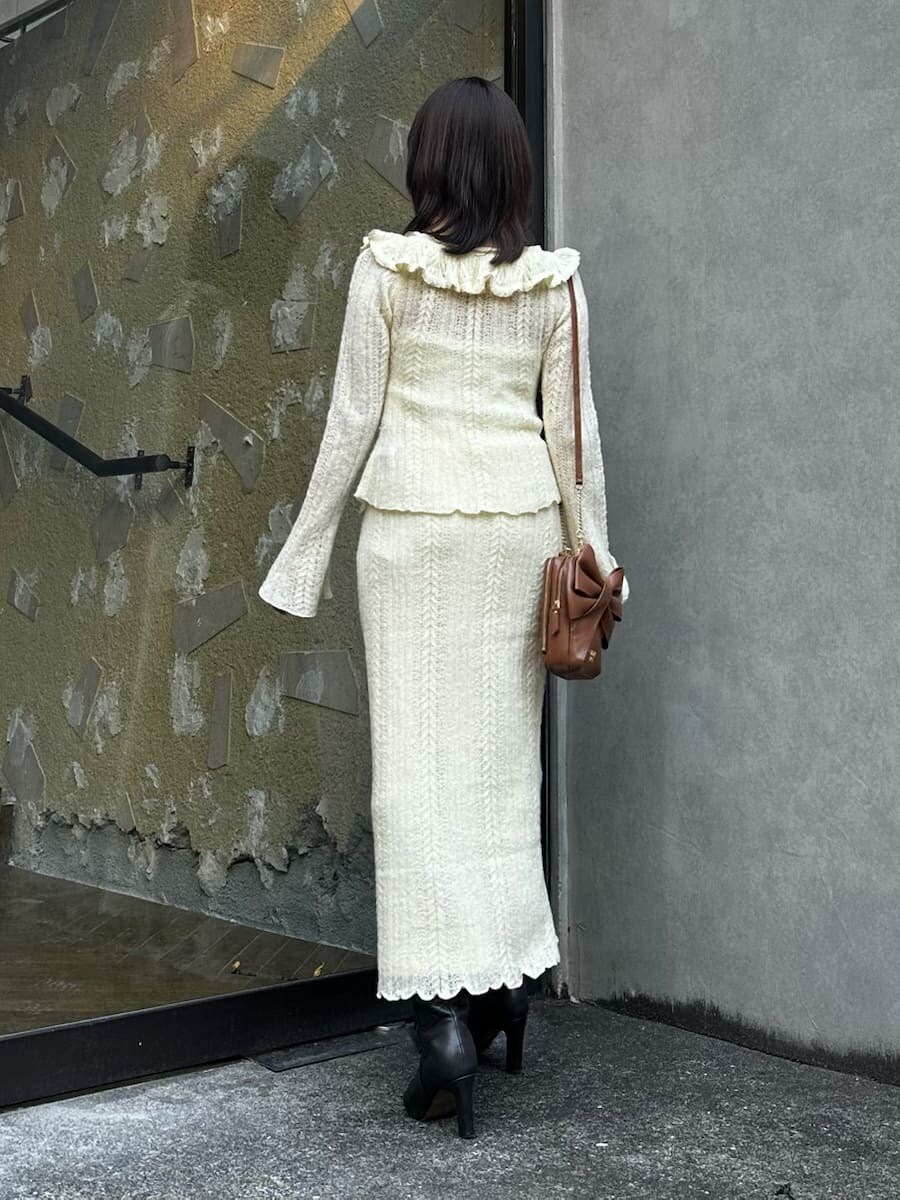 グレー系のブーツ、イエロー系のスカート、イエロー系のニット/セーターを着用したレディースの秋コーディネートの6枚目の写真