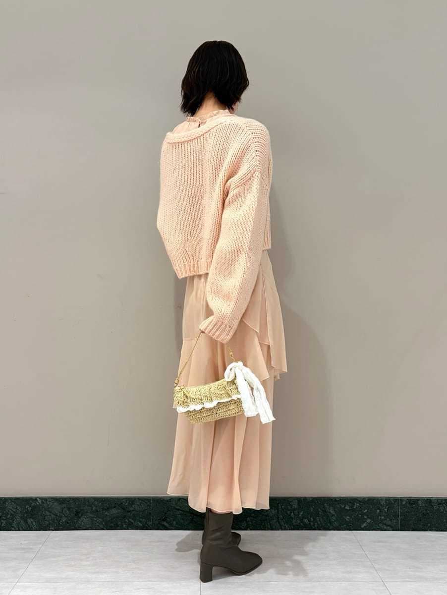 ピンク系のワンピース、ピンク系のカーディガン/ボレロ、ゴールド系のイヤリングを着用したレディースの冬コーディネートの3枚目の写真