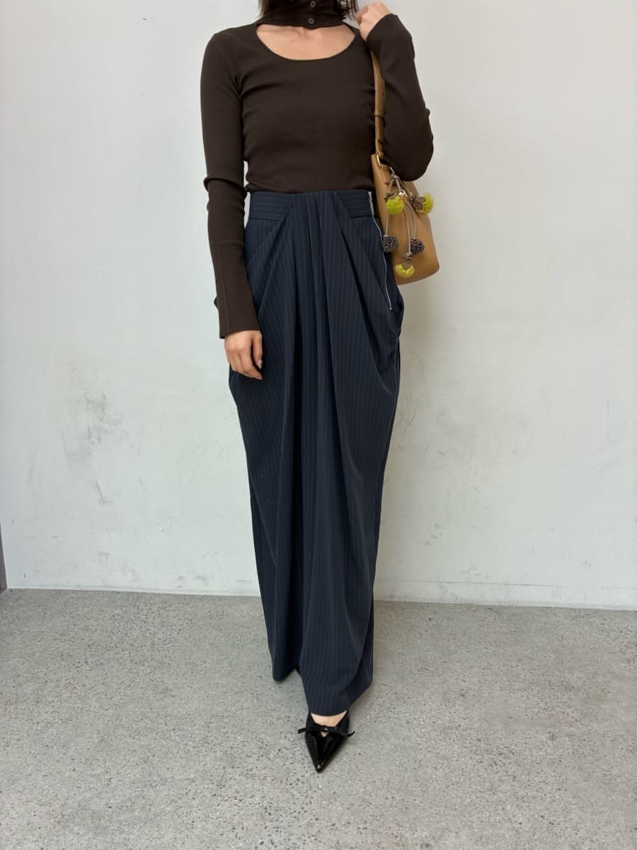 イエロー系のトートバッグ、グレー系のチェスターコート、ブルー系のその他パンツを着用したレディースの冬コーディネートの4枚目の写真