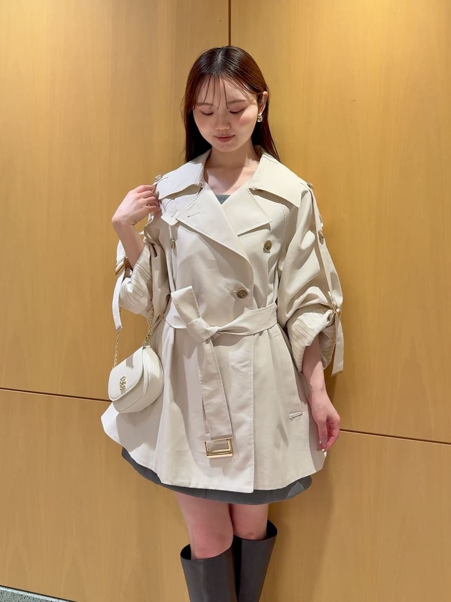 グレー系のブーツ、ホワイト系のトレンチコート、グレー系のワンピースを着用したレディースの冬コーディネートの7枚目の写真