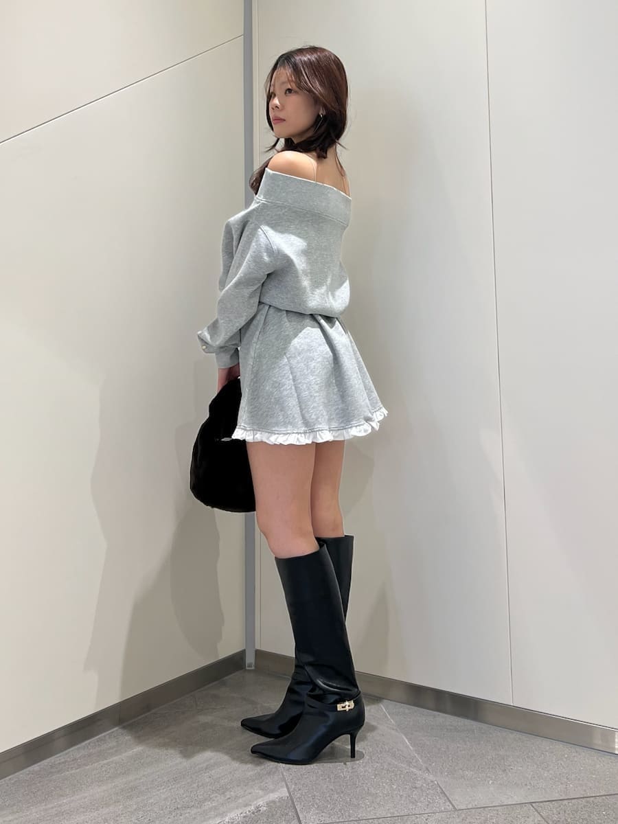 グレー系のワンピース、ブラック系のブーツ、ブラウン系のショルダーバッグを着用したレディースの秋コーディネートの4枚目の写真