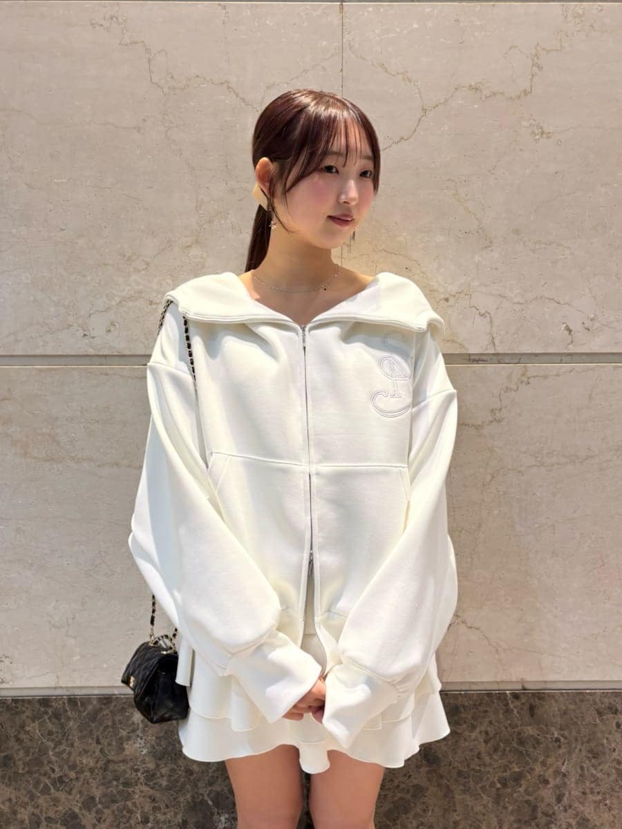 ブラウン系のブーツ、ブラック系のショルダーバッグ、ホワイト系のパーカーを着用したレディースの冬コーディネートの5枚目の写真