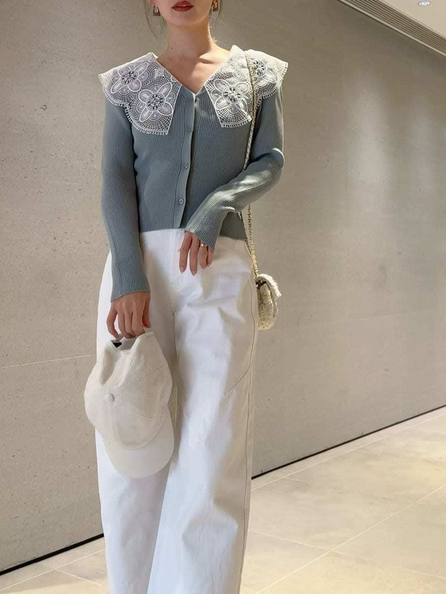 ホワイト系のショルダーバッグ、グリーン系のニット/セーター、ホワイト系のキャップを着用したレディースの冬コーディネートの5枚目の写真