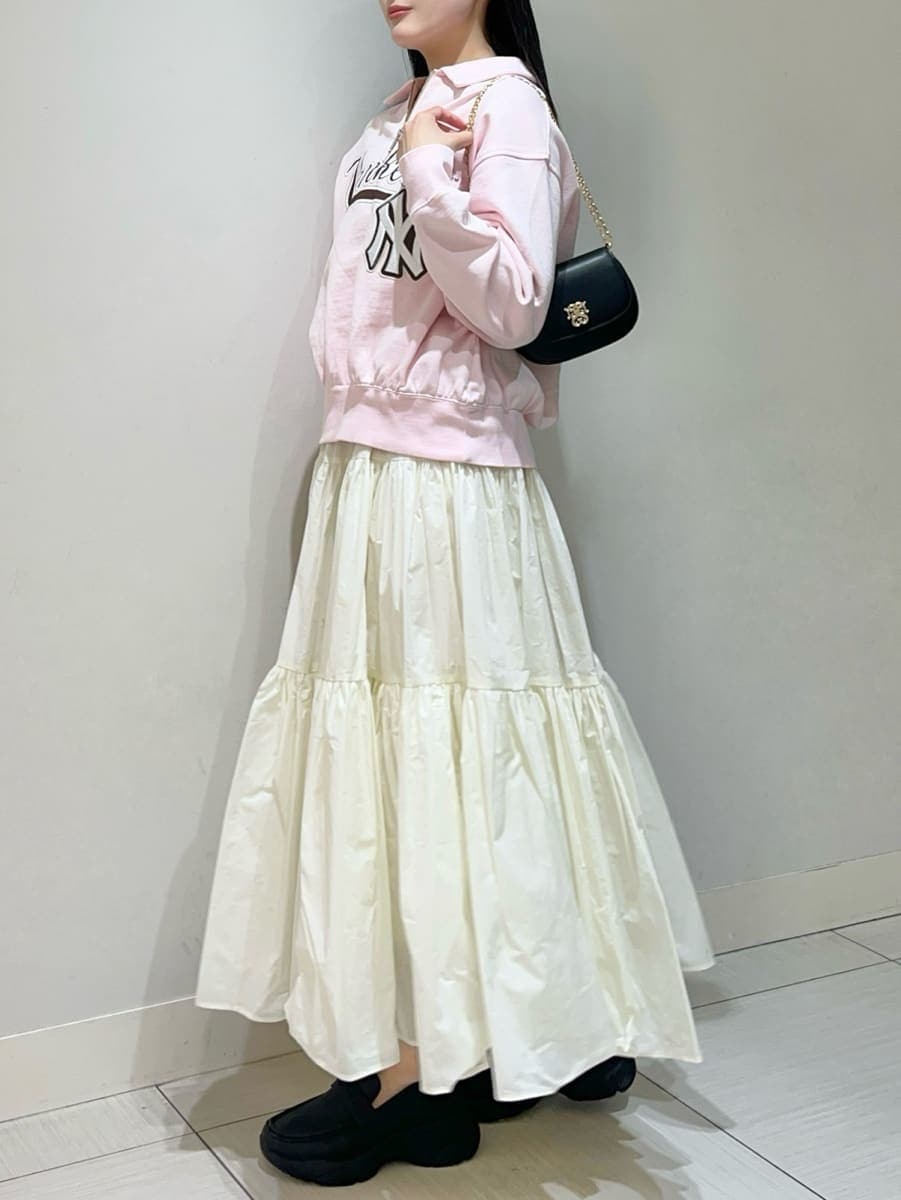 ホワイト系のスカート、ピンク系のスウェット、ブラック系のショルダーバッグを着用したレディースの春コーディネートの2枚目の写真