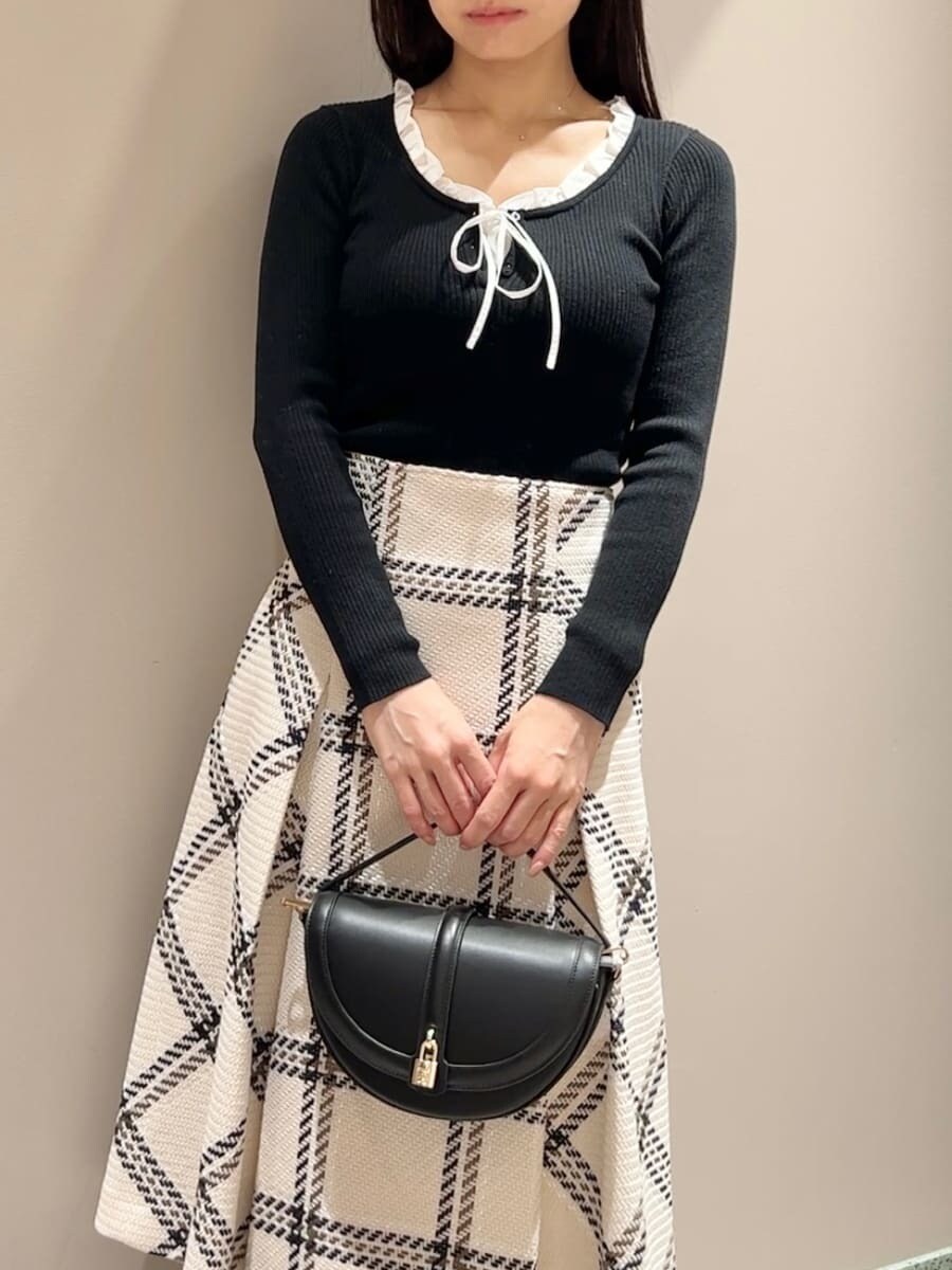 ブラック系のニット/セーター、ホワイト系のスカート、ブラック系のハンドバッグを着用したレディースの秋コーディネートの4枚目の写真