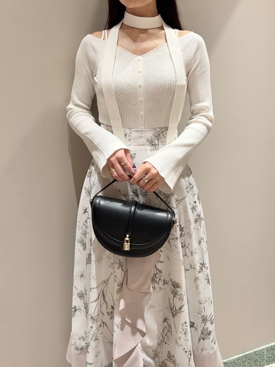 ホワイト系のニット/セーター、ベージュ系のスカート、ブラック系のハンドバッグを着用したレディースの秋コーディネートの3枚目の写真