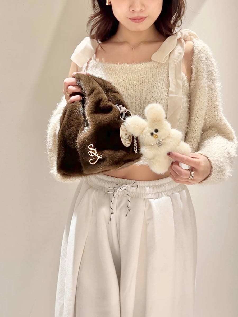 レッド系のブーツ、ホワイト系のニット/セーター、ホワイト系のスウェットパンツを着用したレディースの冬コーディネートの6枚目の写真