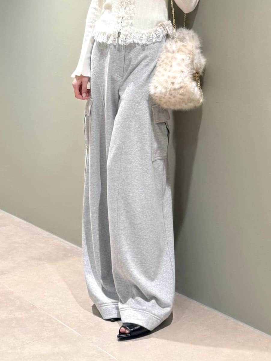 グレー系のその他パンツ、ホワイト系のニット/セーター、ブラック系のサンダルを着用したレディースの夏コーディネートの5枚目の写真