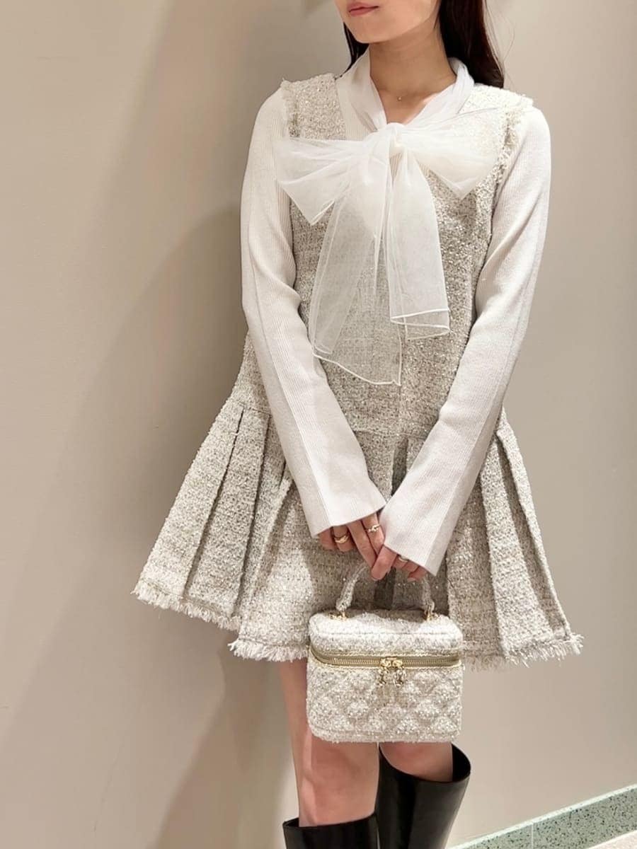 ホワイト系のニット/セーター、ブラック系のブーツ、ブラック系のダウンジャケット/コートを着用したレディースの冬コーディネートの5枚目の写真