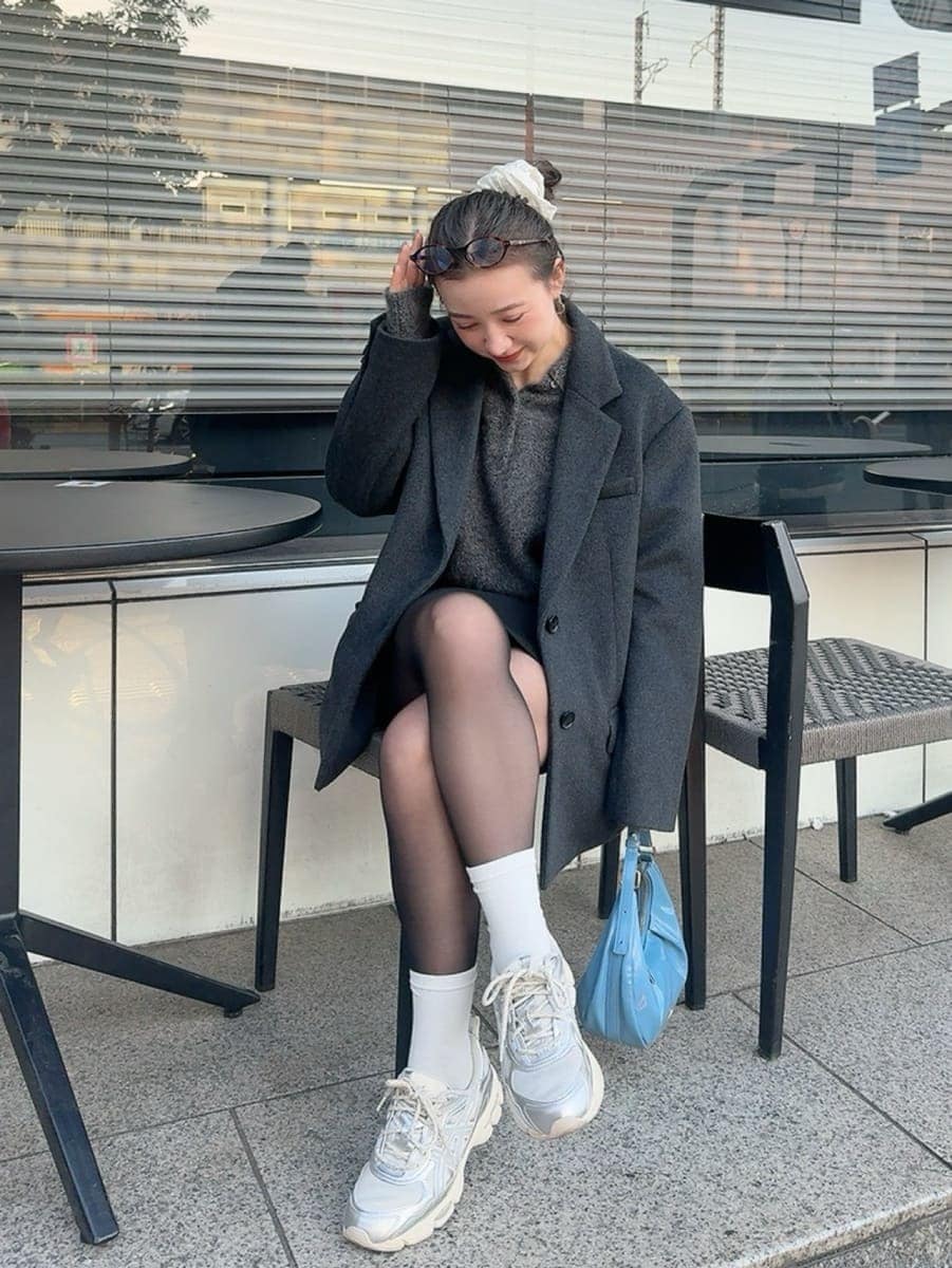 グレー系のニット/セーター、グレー系のテーラードジャケットを着用したレディースの冬コーディネートの5枚目の写真