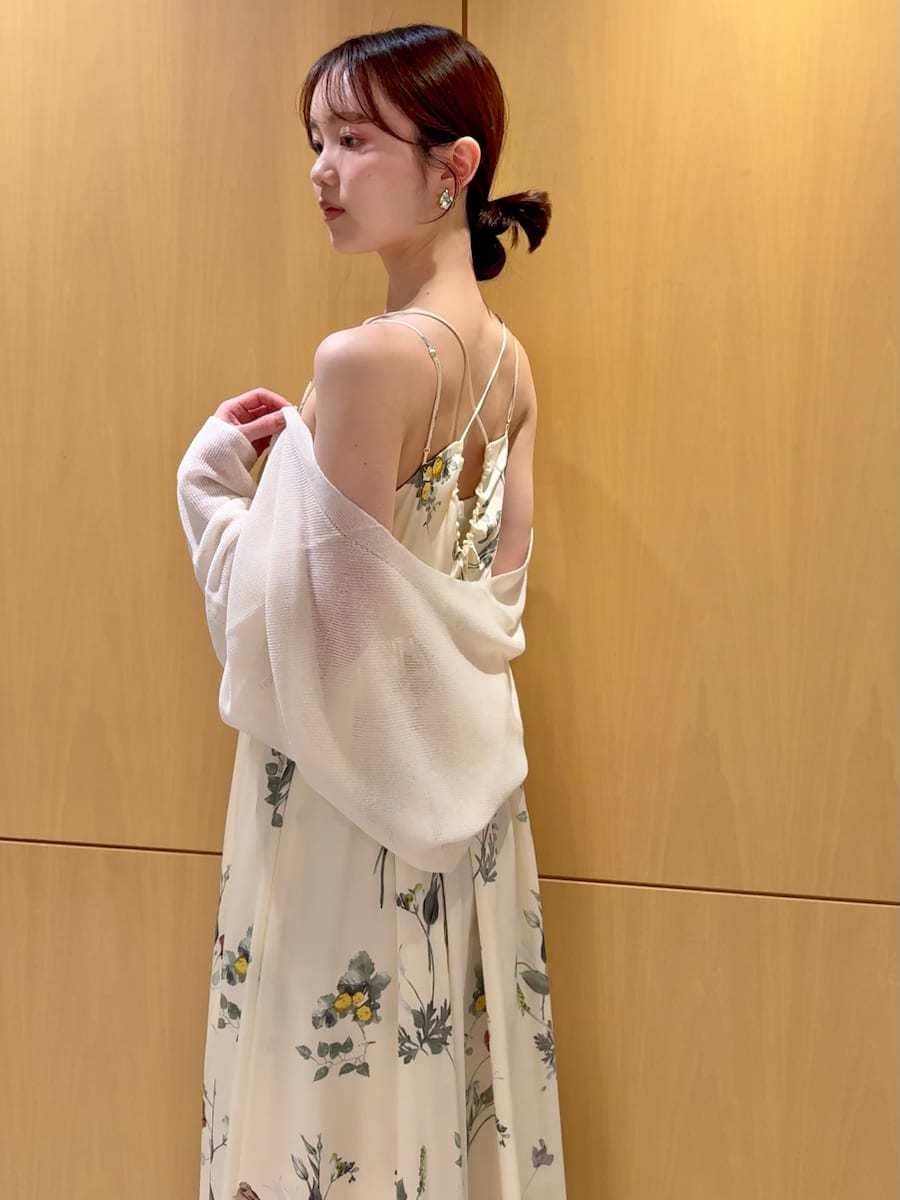 イエロー系のワンピース、ホワイト系のカーディガン/ボレロ、ベージュ系のショルダーバッグを着用したレディースの春コーディネートの6枚目の写真