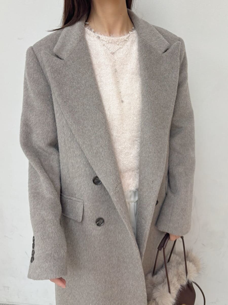 レッド系のブーツ、グレー系のチェスターコート、ホワイト系のスカートを着用したレディースの冬コーディネートの7枚目の写真