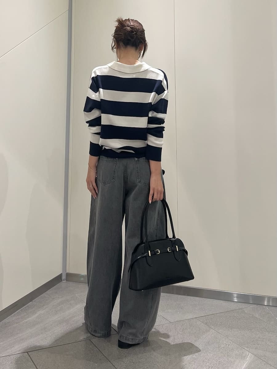 グレー系のデニムパンツ、ブルー系のポロシャツ、ブラック系のボストンバッグを着用したレディースの夏コーディネートの3枚目の写真