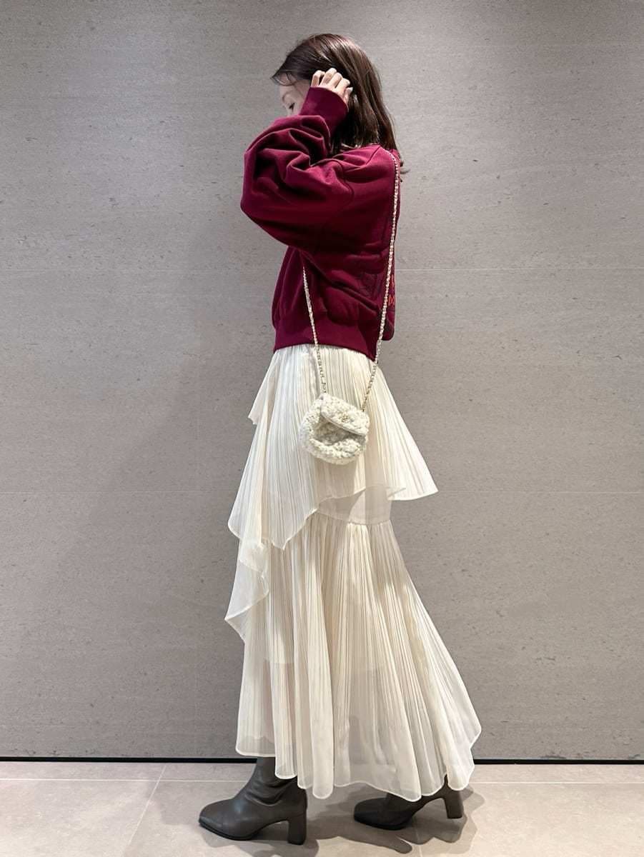 レッド系のスウェット、ホワイト系のスカート、ホワイト系のショルダーバッグを着用したレディースの秋コーディネートの4枚目の写真