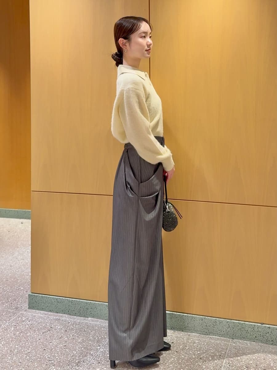 ブラック系のブーツ、イエロー系のニット/セーター、グレー系のその他パンツを着用したレディースの冬コーディネートの2枚目の写真