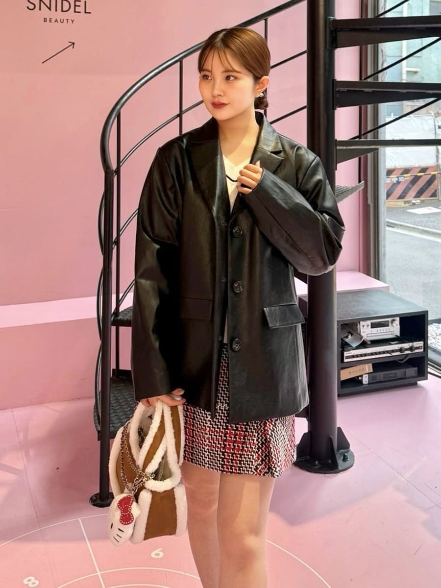 ブラック系のテーラードジャケット、ホワイト系のニット/セーター、レッド系のスカートを着用したレディースの秋コーディネートの5枚目の写真