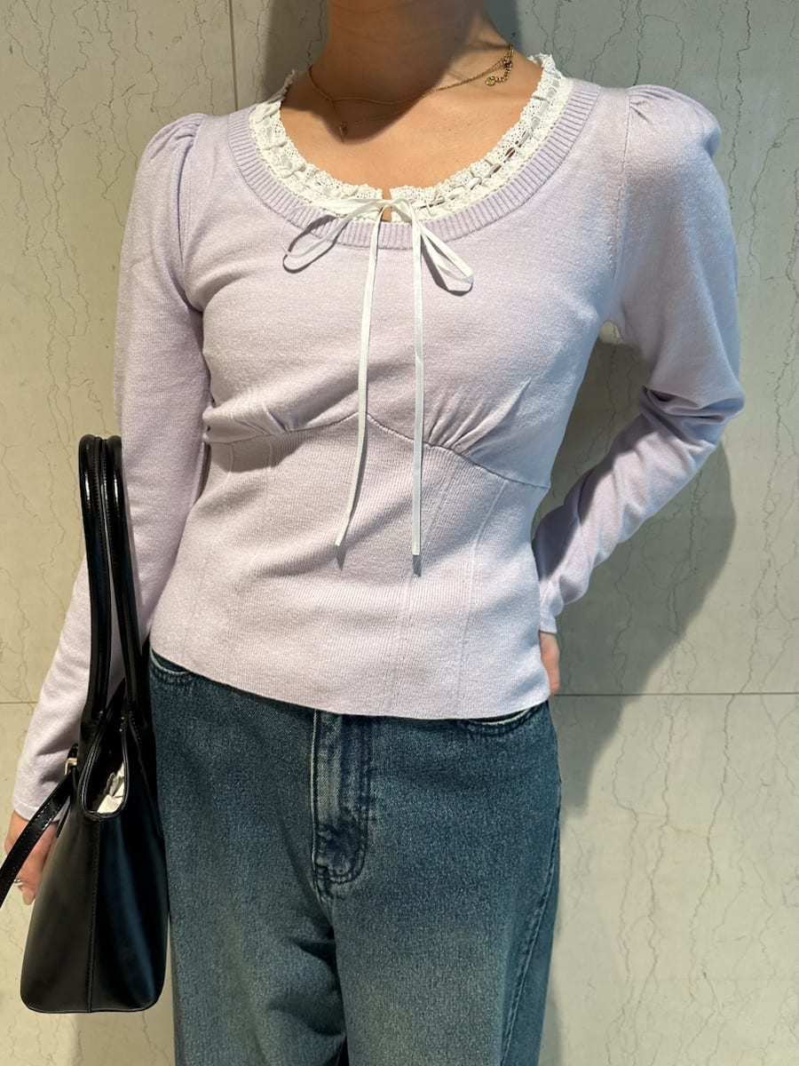ブルー系のデニムパンツ、パープル系のニット/セーター、ブラック系のボストンバッグを着用したレディースの秋コーディネートの3枚目の写真