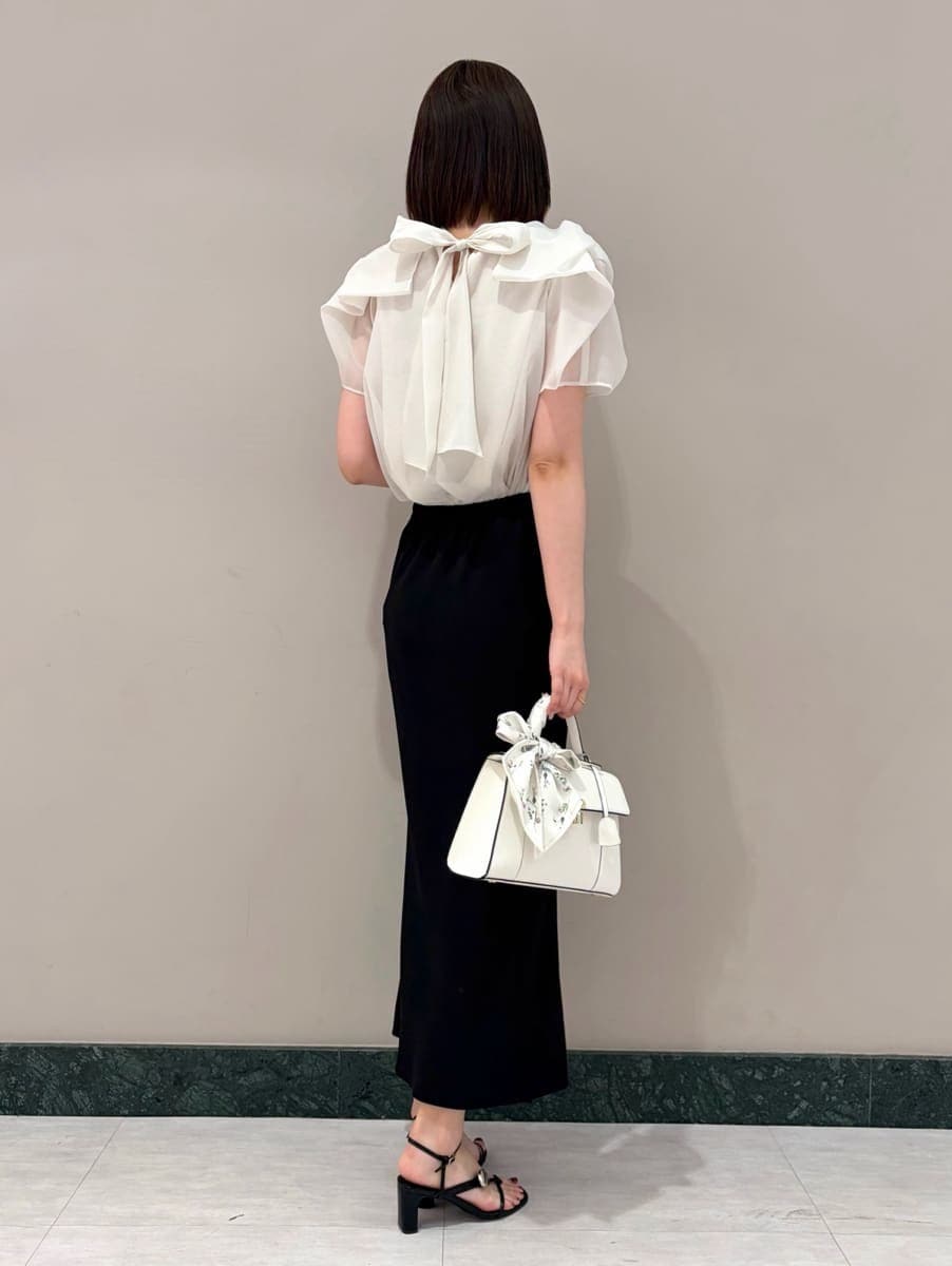 ブラック系のスカート、ホワイト系のシャツ/ブラウス、ホワイト系のハンドバッグを着用したレディースの春コーディネートの3枚目の写真