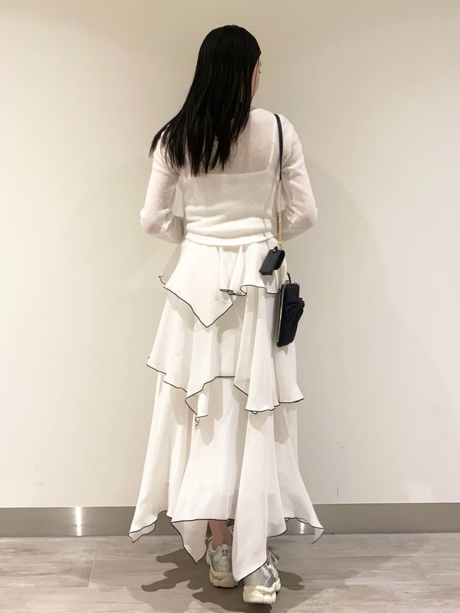 ホワイト系のワンピース、ブラック系のショルダーバッグ、シルバー系のスニーカーを着用したレディースの冬コーディネートの3枚目の写真