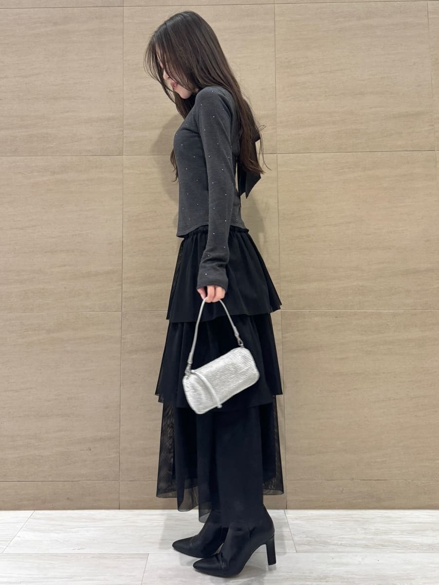 ブラック系のブーツ、ブラック系のスカート、グレー系のニット/セーターを着用したレディースの冬コーディネートの4枚目の写真