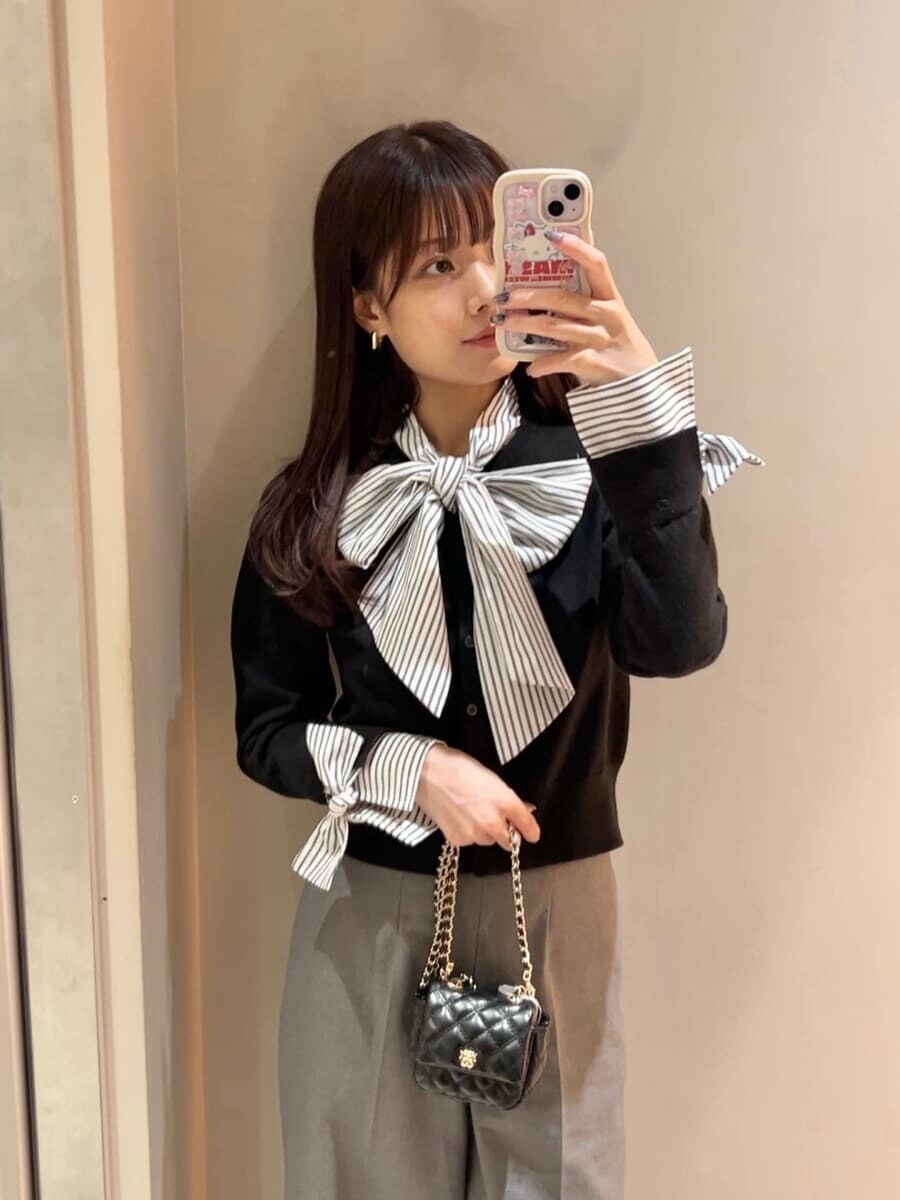 ブラック系のニット/セーター、グレー系のスラックス、ブラック系のショルダーバッグを着用したレディースの秋コーディネートの6枚目の写真