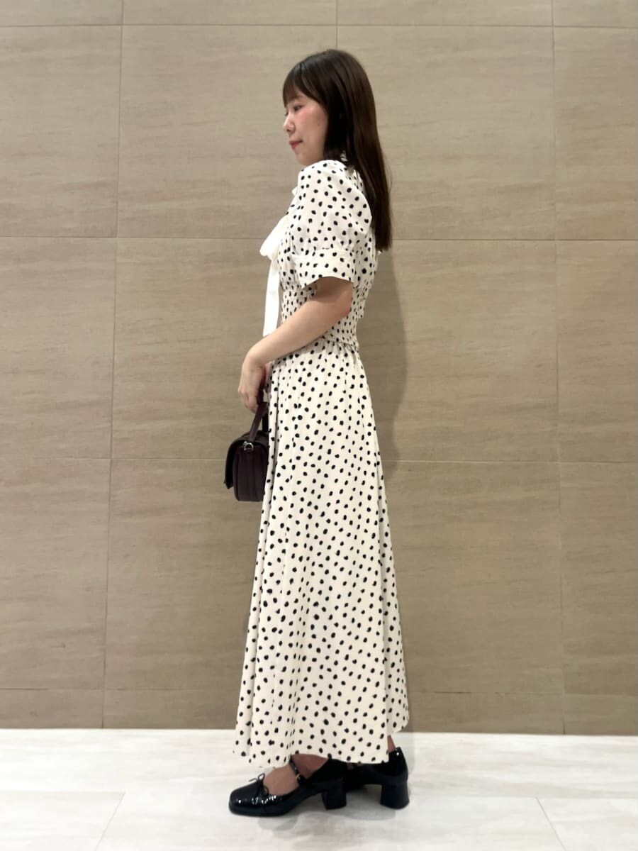 ホワイト系のワンピース、ブラウン系のハンドバッグ、ブラック系のパンプスを着用したレディースの秋コーディネートの2枚目の写真