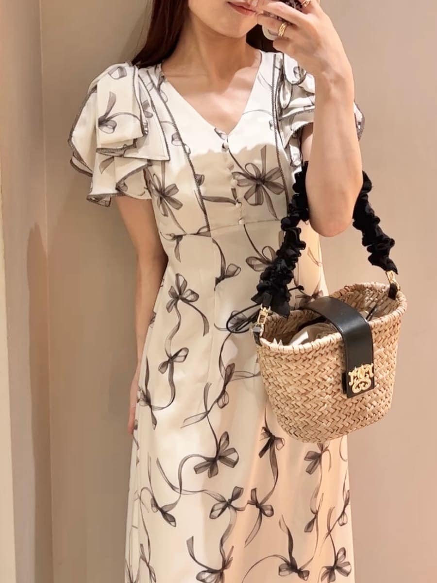 ホワイト系のワンピース、ブラック系のかごバッグ、ホワイト系のサンダルを着用したレディースの夏コーディネートの6枚目の写真