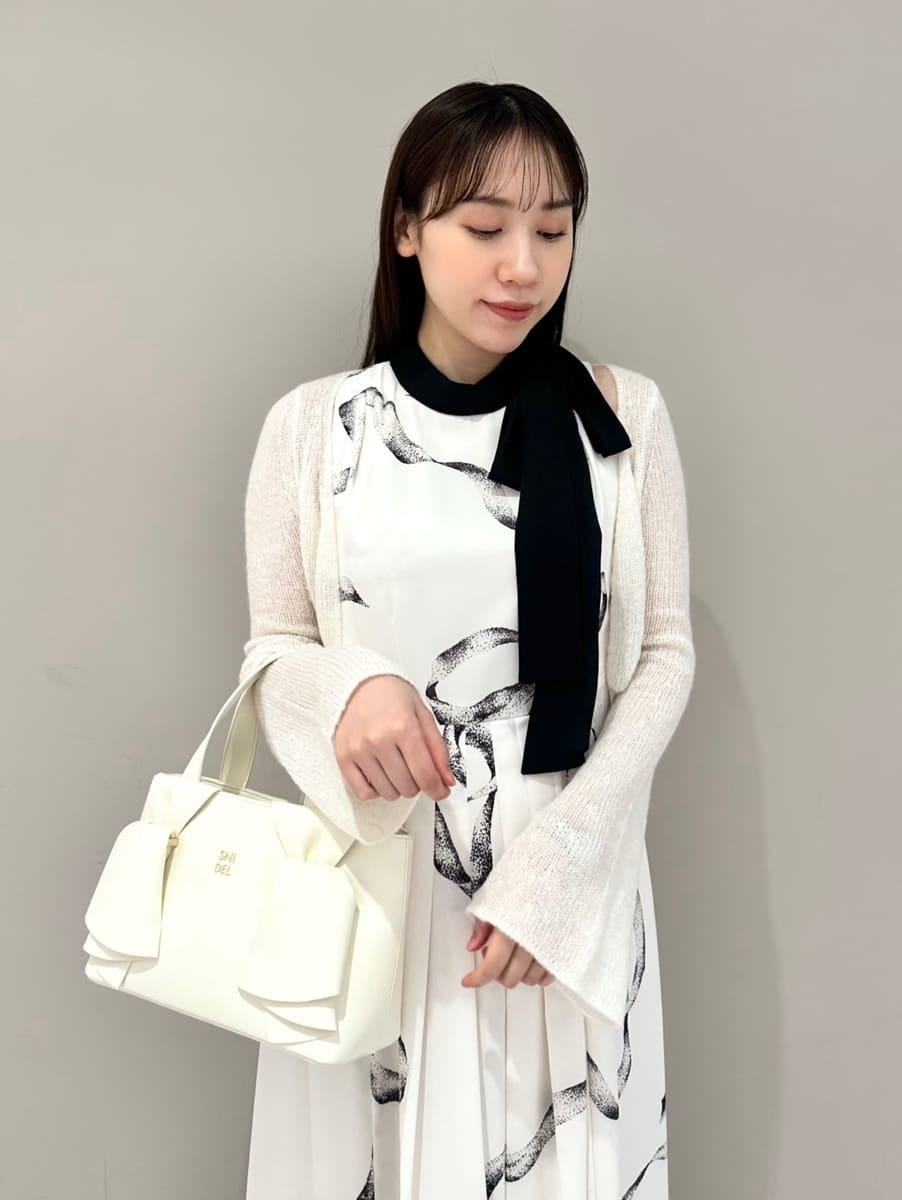 ホワイト系のワンピース、ホワイト系のハンドバッグを着用したレディースの冬コーディネートの2枚目の写真