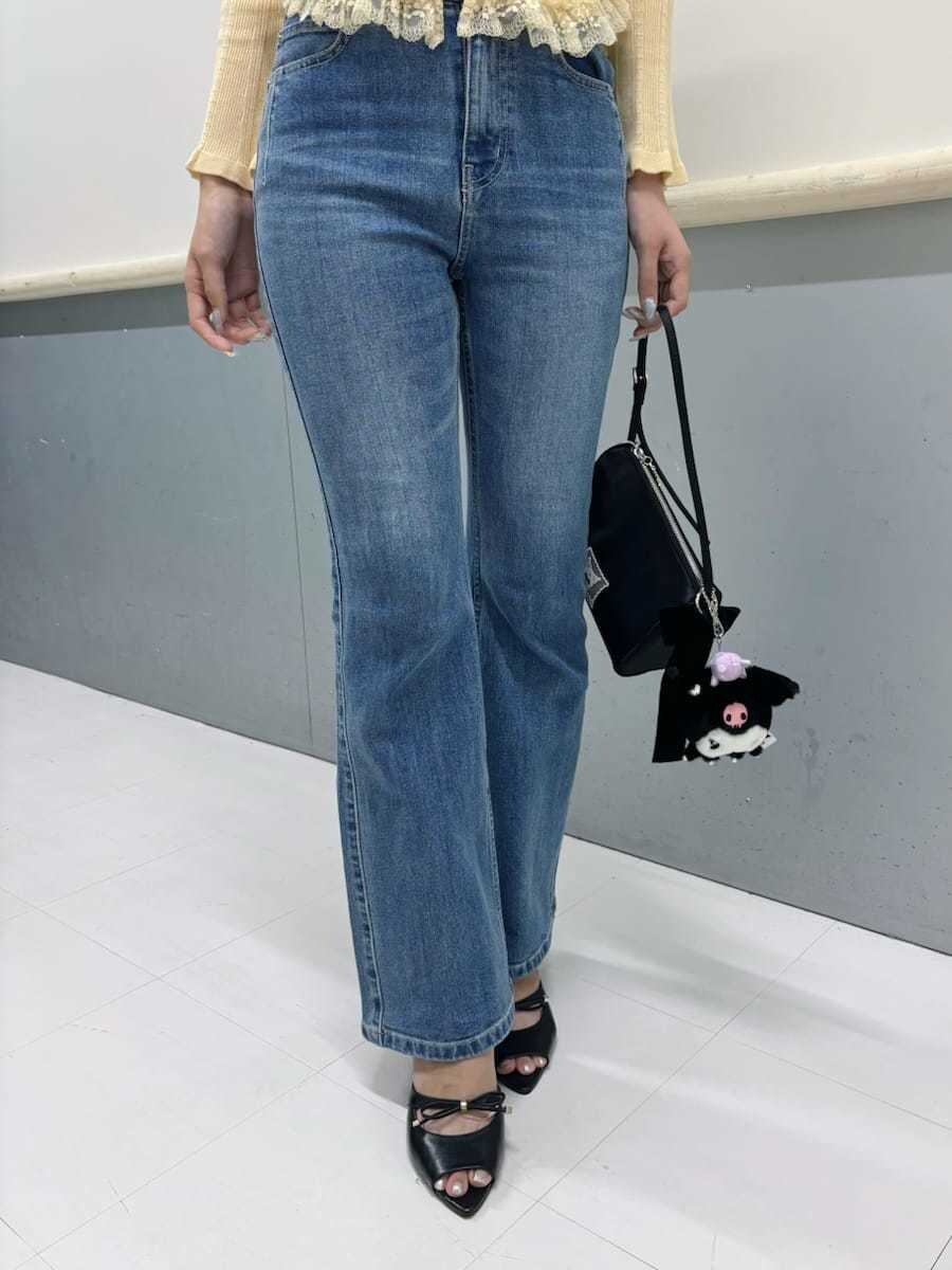 イエロー系のニット/セーター、ブラック系のサンダル、ブルー系のデニムパンツを着用したレディースの夏コーディネートの4枚目の写真