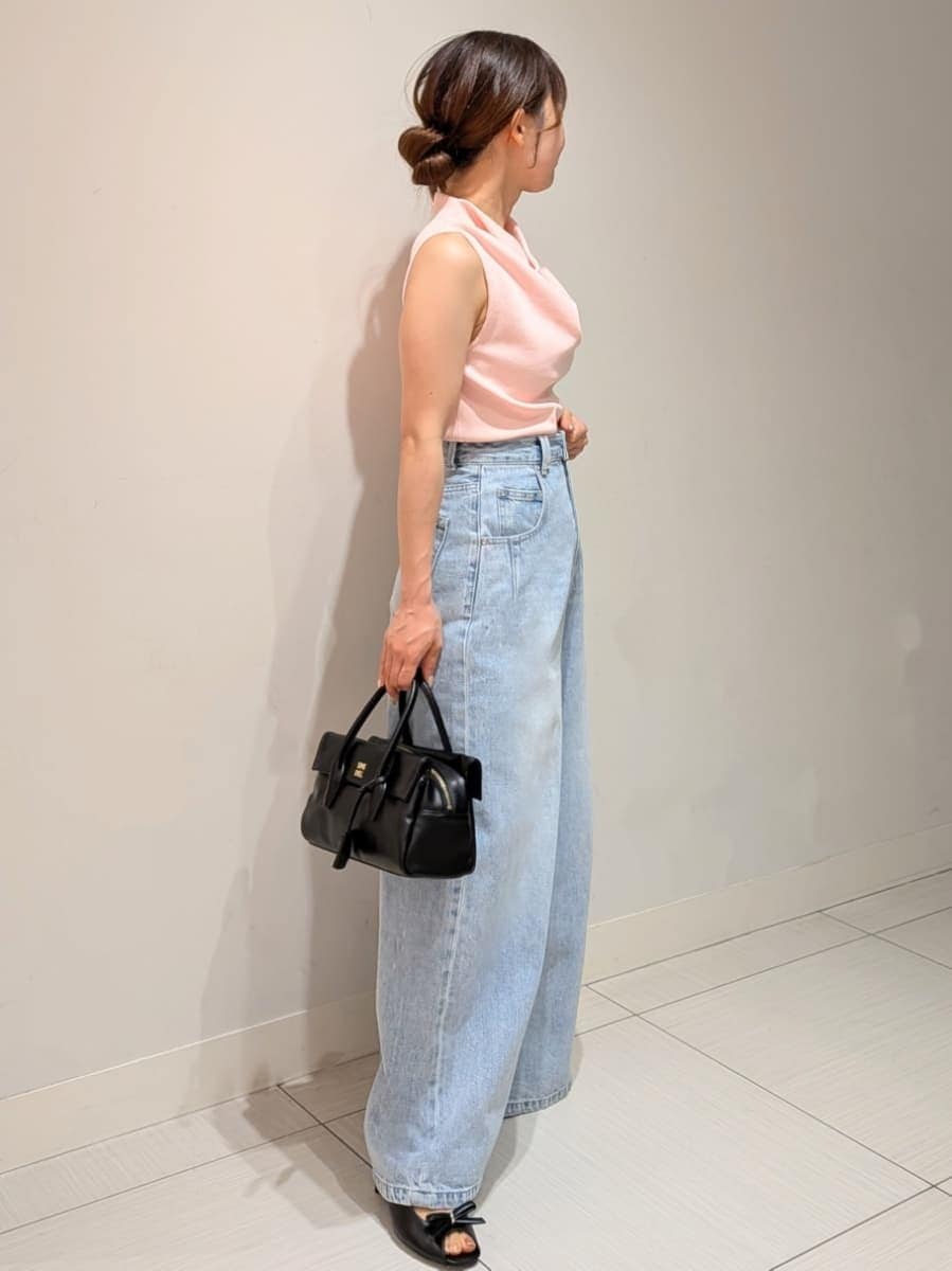ブルー系のデニムパンツ、ピンク系のニット/セーター、ブラック系のボストンバッグを着用したレディースの夏コーディネートの2枚目の写真