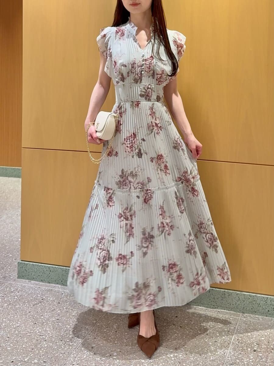 グリーン系のワンピース、ブラウン系のパンプス、ホワイト系のショルダーバッグを着用したレディースの春コーディネートの6枚目の写真