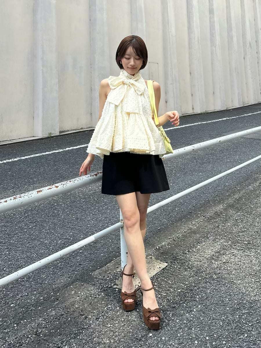 ブラック系のその他パンツ、ホワイト系のシャツ/ブラウス、イエロー系のショルダーバッグを着用したレディースの春コーディネートの4枚目の写真