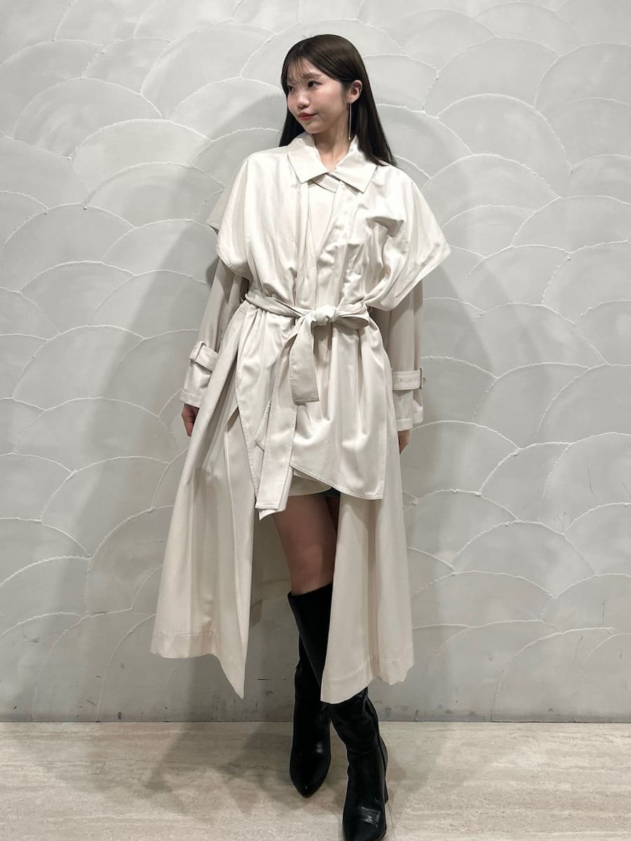 ブラック系のブーツ、ホワイト系のトレンチコート、グレー系のワンピースを着用したレディースの冬コーディネートの6枚目の写真