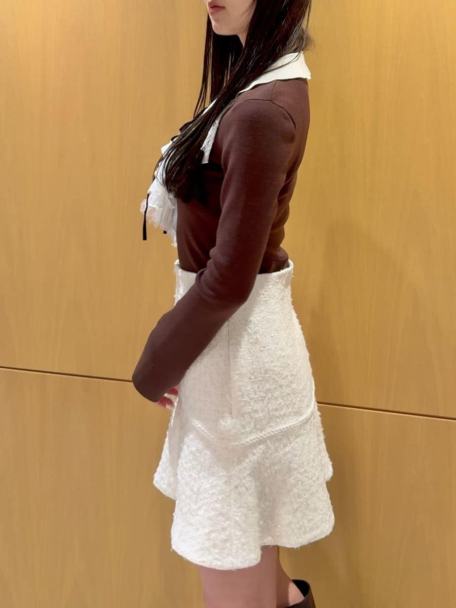 ホワイト系のショルダーバッグ、ブラウン系のニット/セーター、ホワイト系のスカートを着用したレディースの冬コーディネートの6枚目の写真