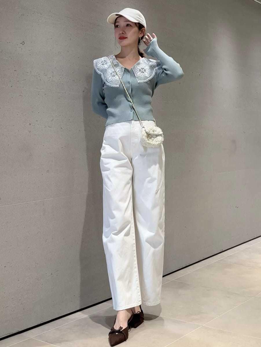 ホワイト系のショルダーバッグ、グリーン系のニット/セーター、ホワイト系のキャップを着用したレディースの冬コーディネートの3枚目の写真