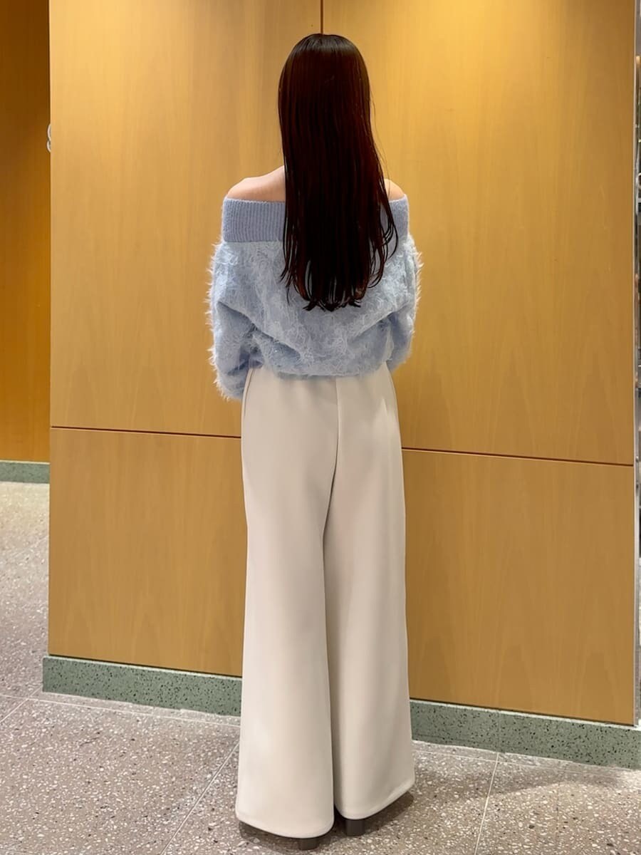 ブラック系のショルダーバッグ、ホワイト系のスウェットパンツ、ブルー系のニット/セーターを着用したレディースの冬コーディネートの3枚目の写真