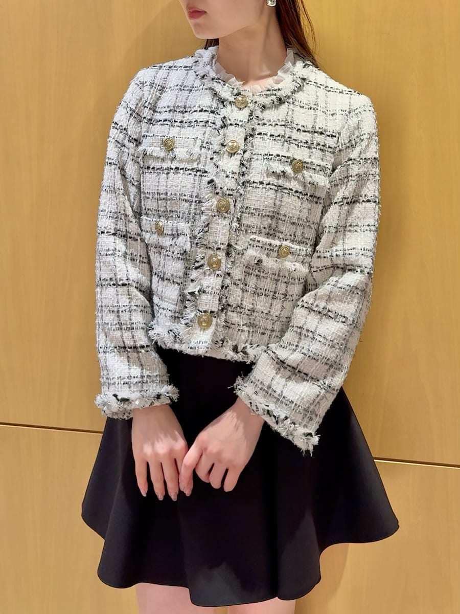 ブラック系のブーツ、ホワイト系のノーカラージャケット、ブラック系のその他パンツを着用したレディースの冬コーディネートの5枚目の写真