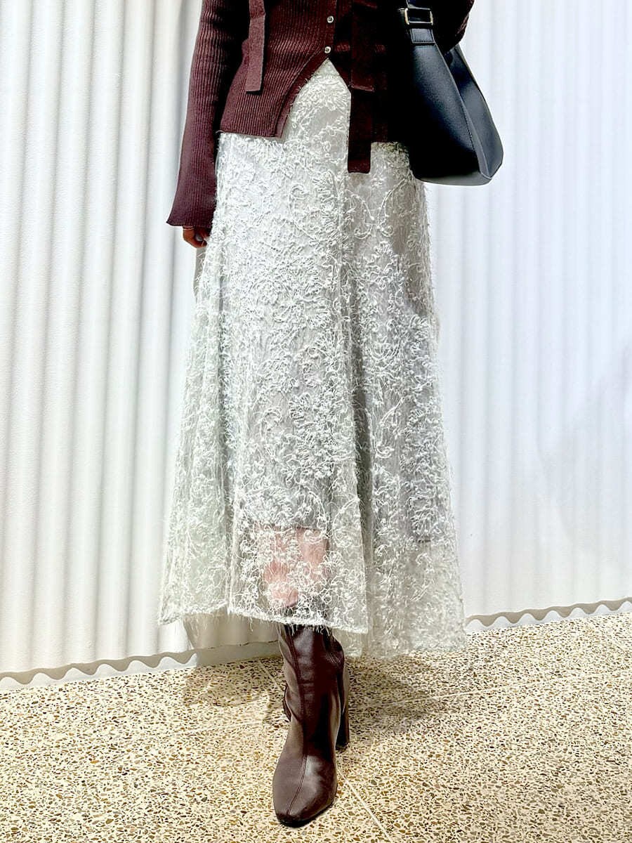 ブラウン系のニット/セーター、グリーン系のスカート、レッド系のブーツを着用したレディースの秋コーディネートの6枚目の写真