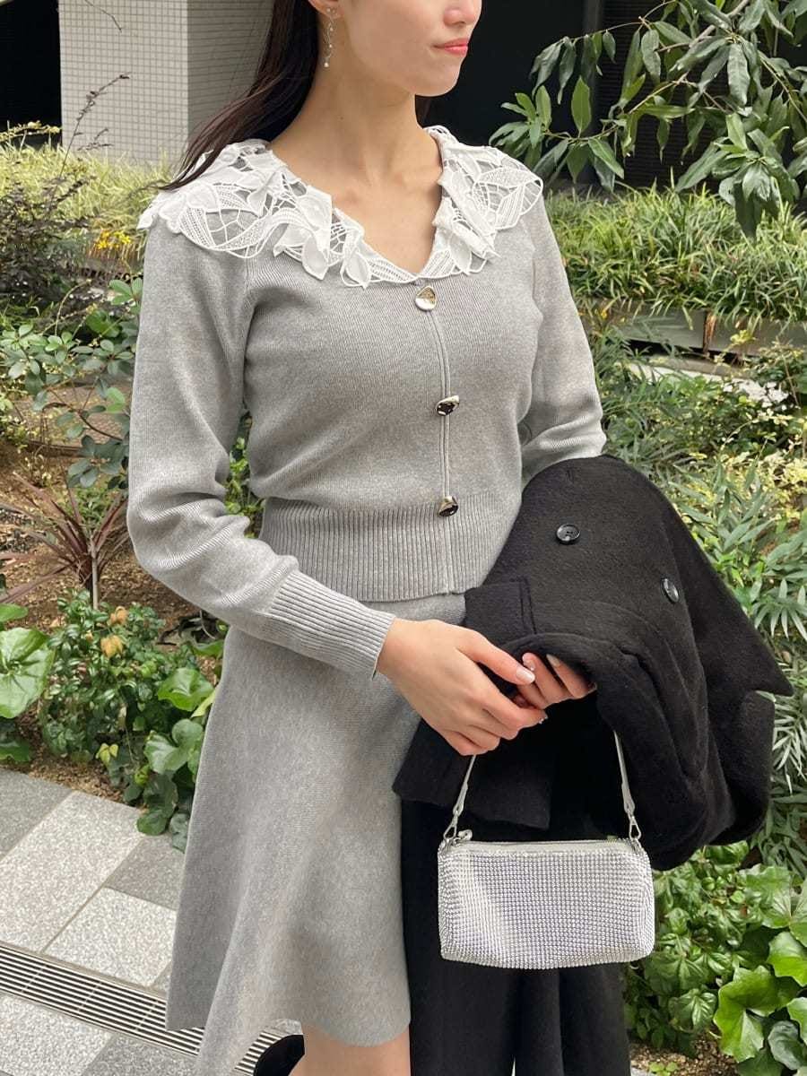 ブラック系のチェスターコート、グレー系のワンピースを着用したレディースの冬コーディネートの6枚目の写真