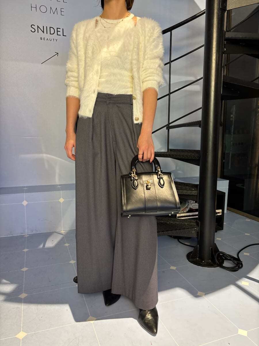 ブラック系のブーツ、ホワイト系のニット/セーター、ブラック系のハンドバッグを着用したレディースの秋コーディネートの7枚目の写真