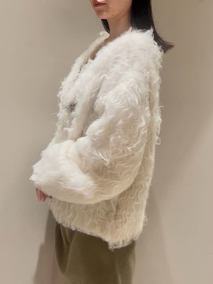 グリーン系のワンピース、ホワイト系のカーディガン/ボレロ、ブラック系のブーツを着用したレディースの秋コーディネートの5枚目の写真