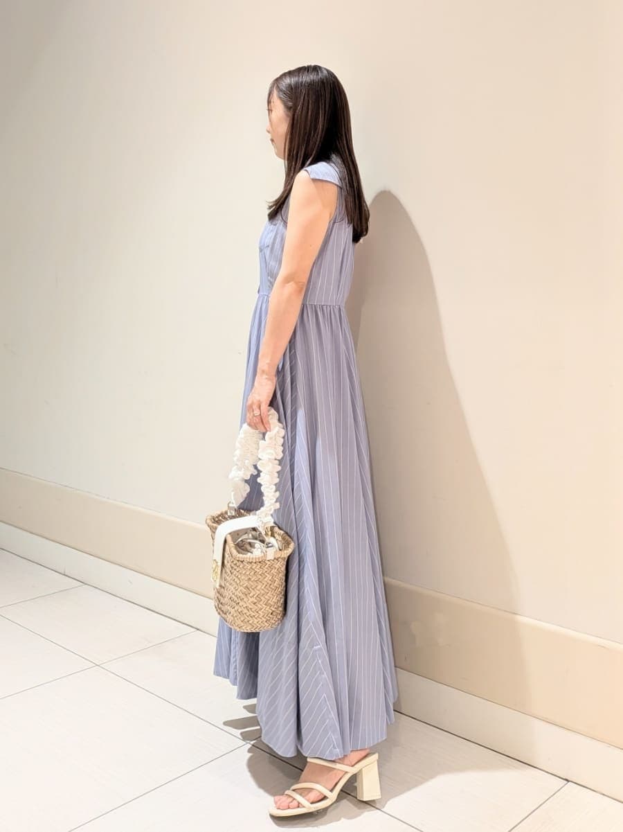 ブルー系のワンピース、ホワイト系のかごバッグ、ホワイト系のパンプスを着用したレディースの夏コーディネートの2枚目の写真