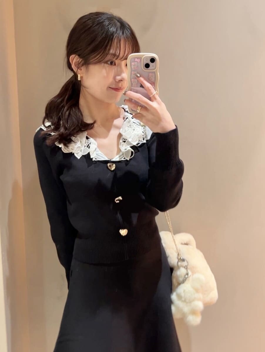 ホワイト系のステンカラーコート、イエロー系のハンドバッグ、ブラック系のワンピースを着用したレディースの冬コーディネートの10枚目の写真