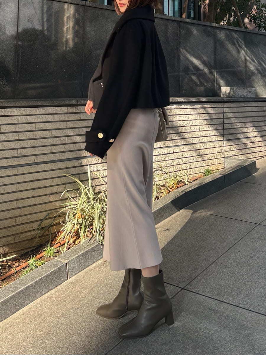 ブラック系のピーコート、ホワイト系のワンピース、ホワイト系のショルダーバッグを着用したレディースの冬コーディネートの3枚目の写真