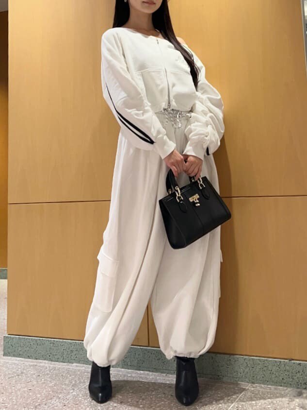 ホワイト系のスウェットパンツ、ホワイト系のスウェット、ブラック系のハンドバッグを着用したレディースの冬コーディネートの2枚目の写真