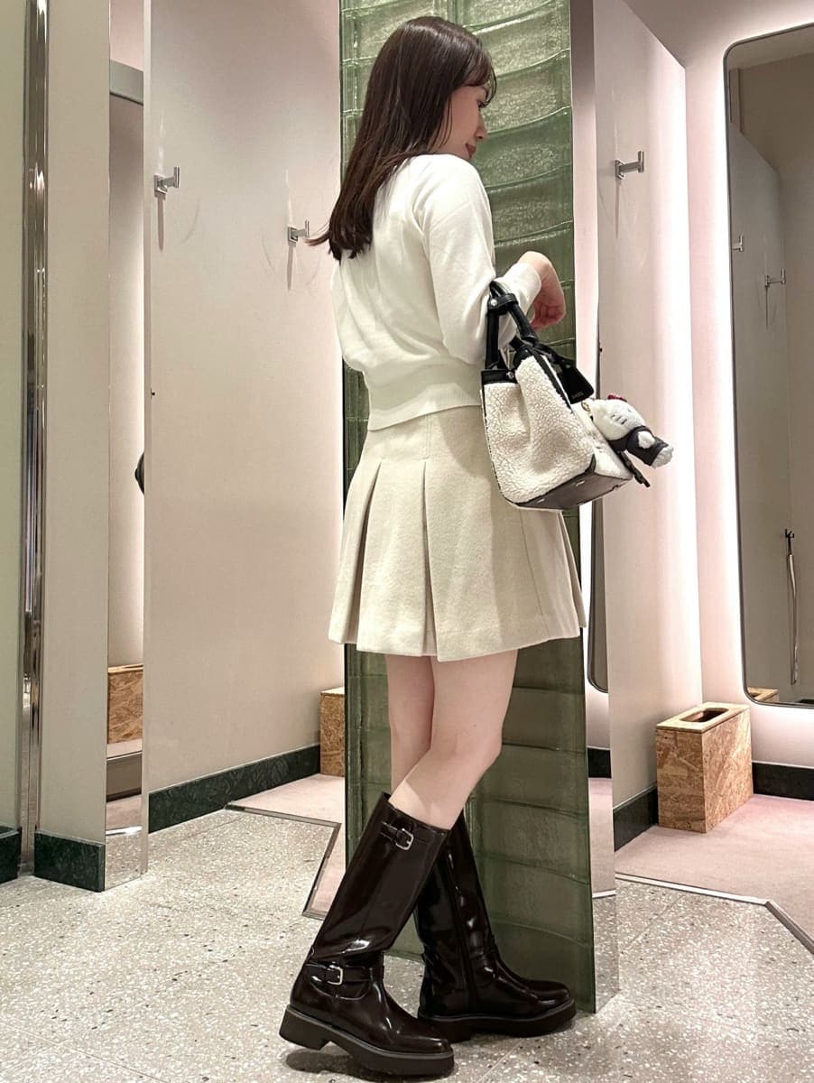 ホワイト系のカーディガン/ボレロ、ホワイト系のスカート、ブラック系のブーツを着用したレディースの秋コーディネートの3枚目の写真