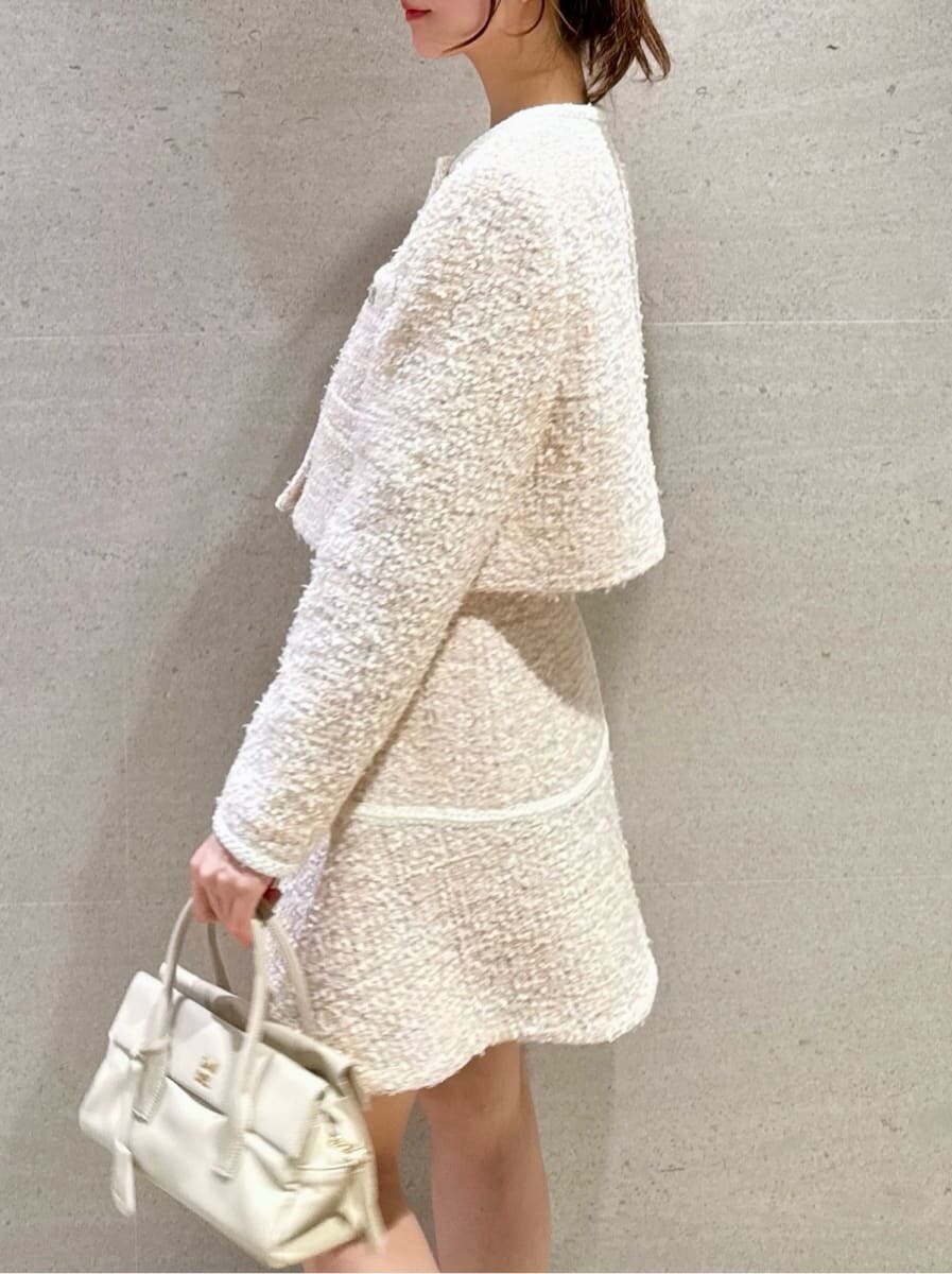 その他のノーカラージャケット、その他のスカート、ホワイト系のボストンバッグを着用したレディースの冬コーディネートの4枚目の写真