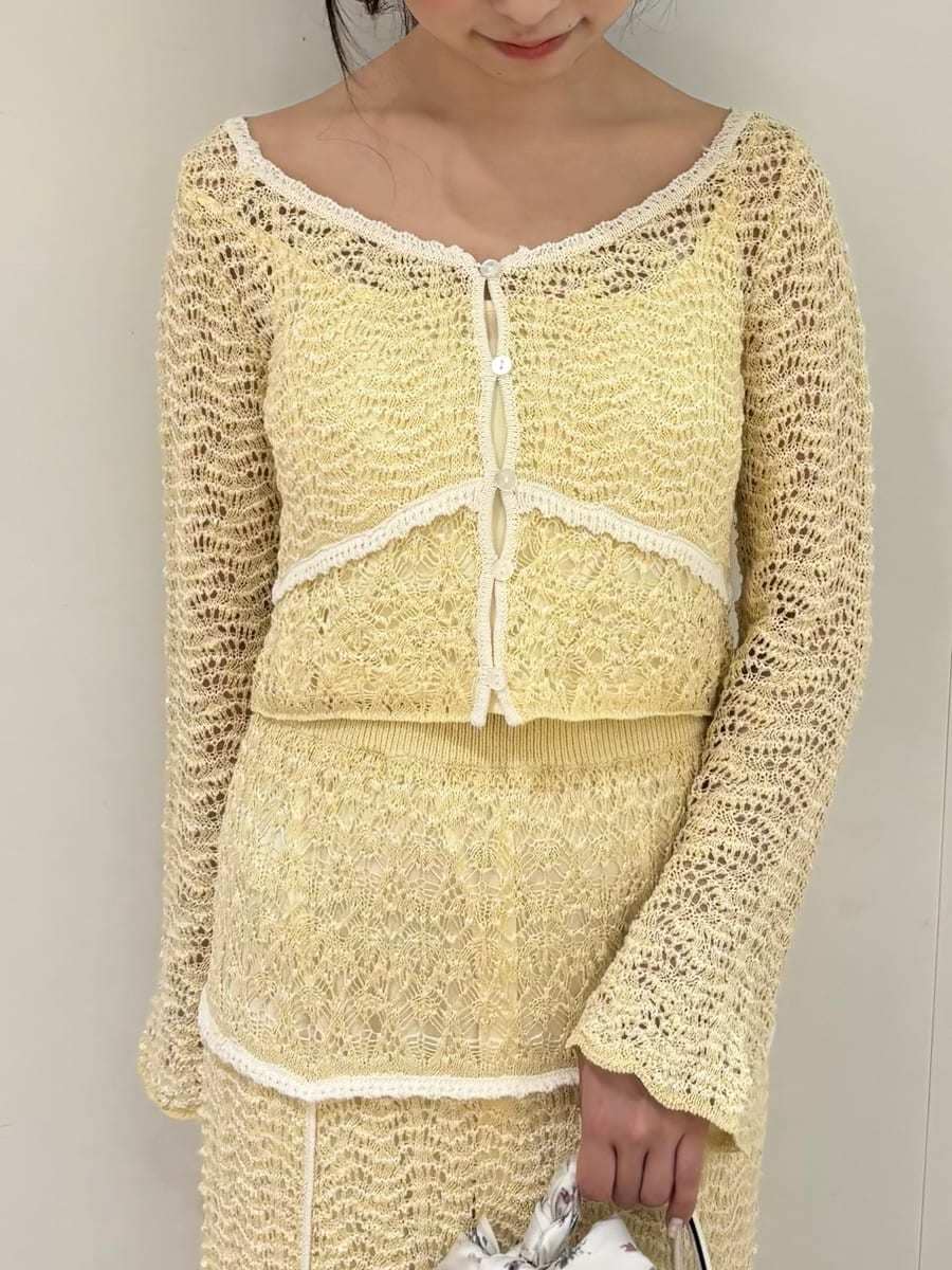 イエロー系のスカート、ブラウン系のパンプス、ホワイト系のハンドバッグを着用したレディースの冬コーディネートの5枚目の写真