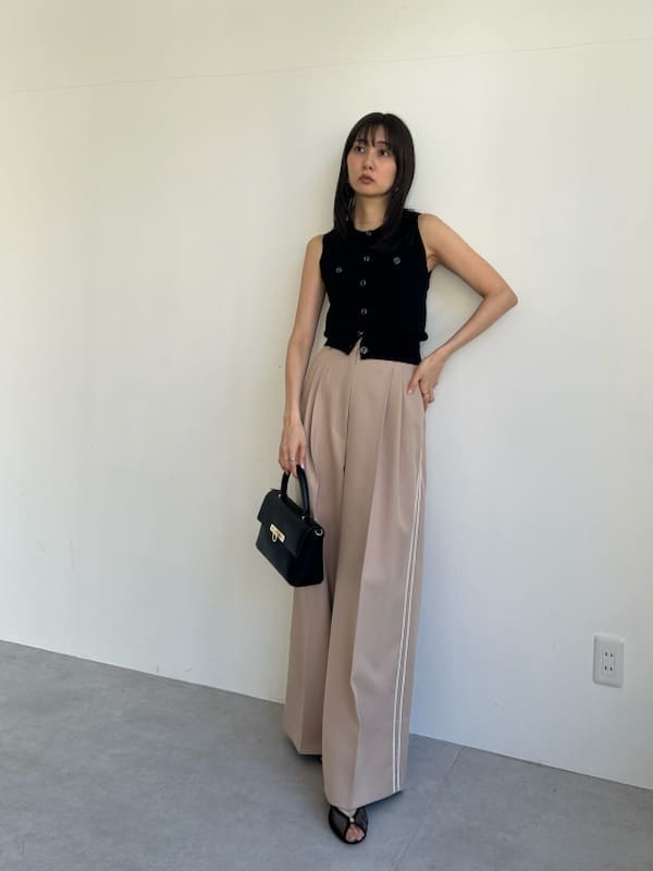 ブラック系のニット/セーター、ベージュ系のその他パンツ、ブラック系のショルダーバッグを着用したレディースの春コーディネートの3枚目の写真