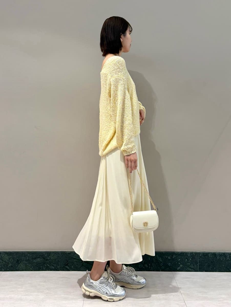 イエロー系のワンピース、ホワイト系のショルダーバッグ、シルバー系のスニーカーを着用したレディースの春コーディネートの2枚目の写真